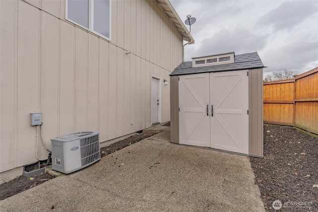 view of shed with fence and central AC