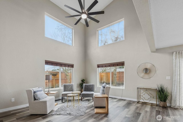 living room featuring baseboards, a healthy amount of sunlight, and wood finished floors