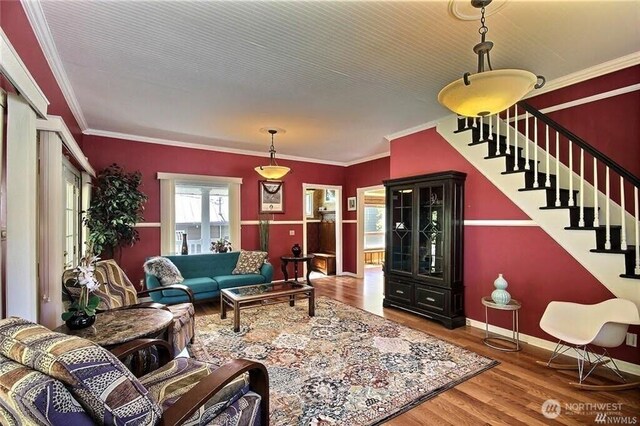 living room with crown molding, stairway, wood finished floors, and baseboards