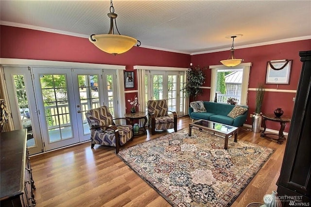 living area featuring french doors, crown molding, baseboards, and wood finished floors