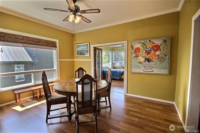 dining area with ceiling fan, baseboards, crown molding, and dark wood-type flooring