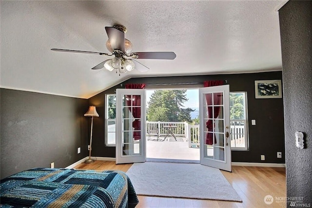 bedroom with french doors, wood finished floors, a textured ceiling, and access to outside