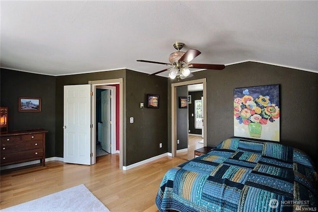 bedroom with light wood finished floors, a ceiling fan, baseboards, and vaulted ceiling