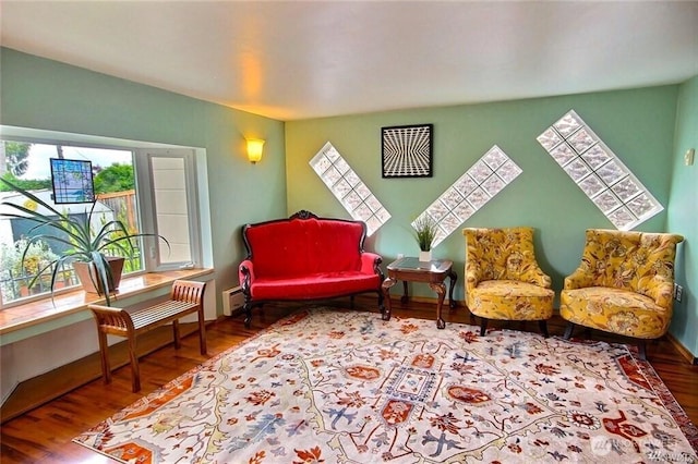 living area with baseboards and wood finished floors