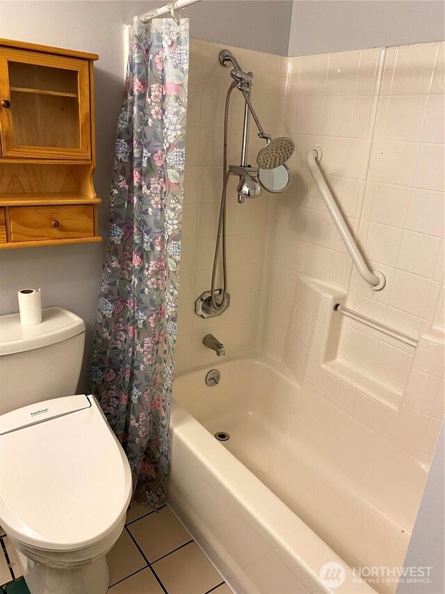 bathroom with tile patterned flooring, shower / tub combo, and toilet