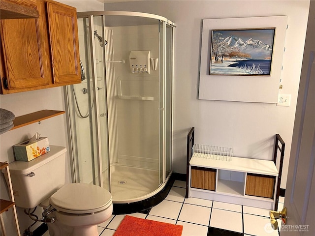 bathroom featuring tile patterned flooring, a shower stall, and toilet