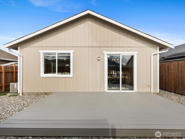 rear view of property featuring a wooden deck and fence