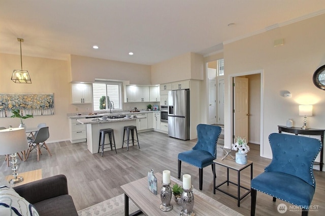 living room with recessed lighting, light wood-type flooring, and baseboards