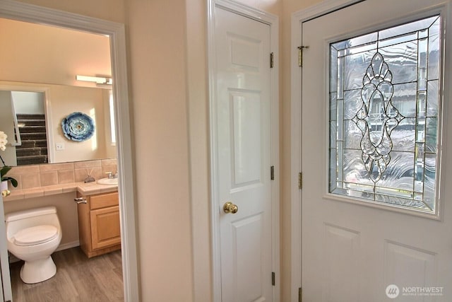 bathroom featuring toilet, a healthy amount of sunlight, wood finished floors, and vanity