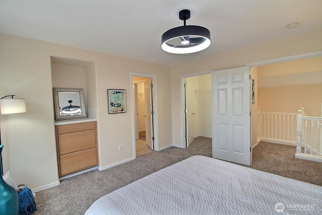 carpeted bedroom featuring a spacious closet, baseboards, and connected bathroom