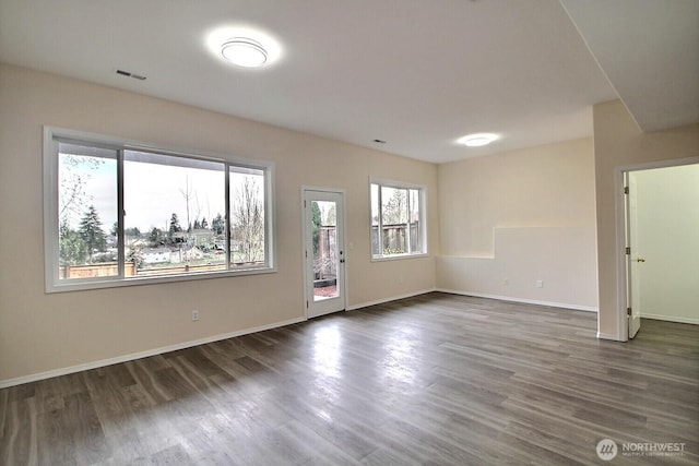 empty room with visible vents, wood finished floors, and baseboards