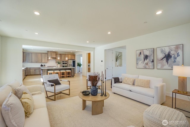 living room with light wood-style flooring and recessed lighting