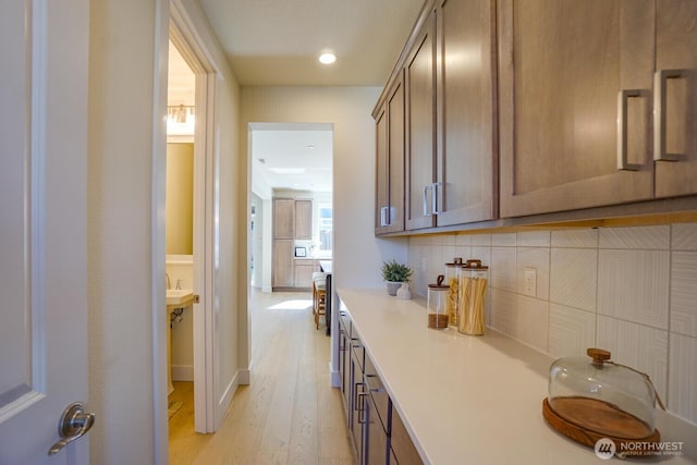 interior space with decorative backsplash, light wood-style floors, and light countertops