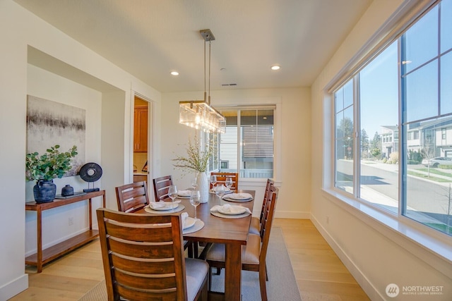 dining space with recessed lighting, light wood-style floors, baseboards, and a notable chandelier