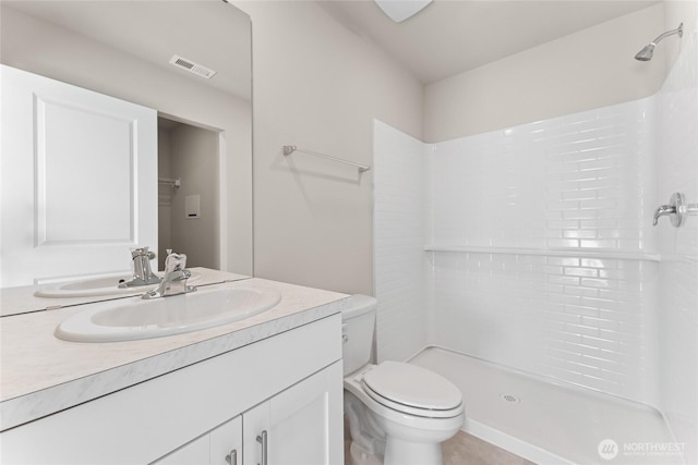 bathroom featuring visible vents, a shower stall, toilet, and vanity