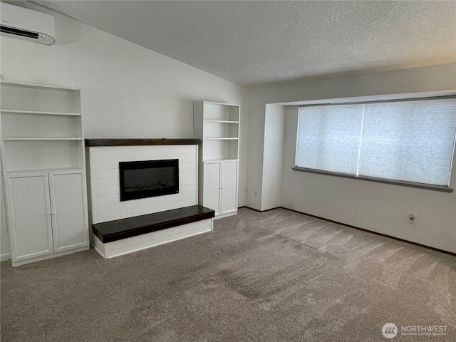 unfurnished living room with a textured ceiling, carpet, a fireplace, and a wall unit AC