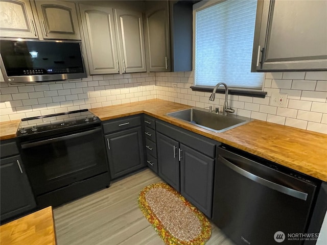 kitchen featuring butcher block countertops, dishwashing machine, stainless steel microwave, and black / electric stove