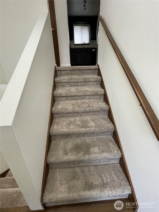 staircase featuring baseboards and wood finished floors