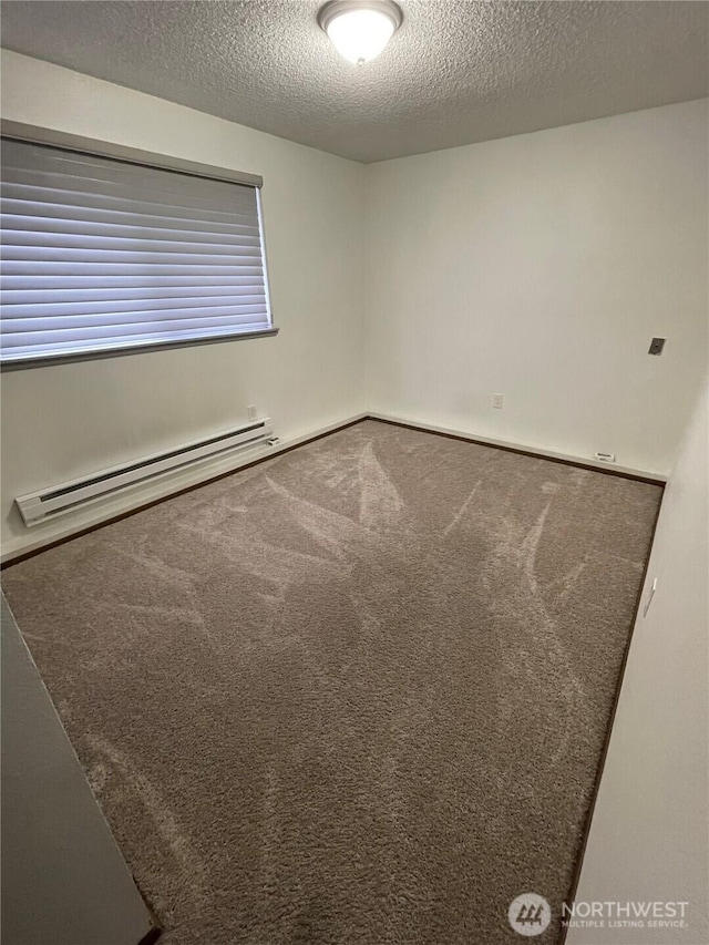 unfurnished room with a textured ceiling, a baseboard heating unit, and carpet floors