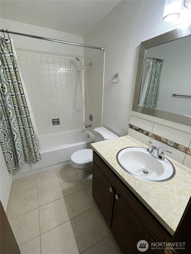 bathroom featuring shower / bathtub combination with curtain, toilet, tile patterned flooring, vanity, and a textured wall