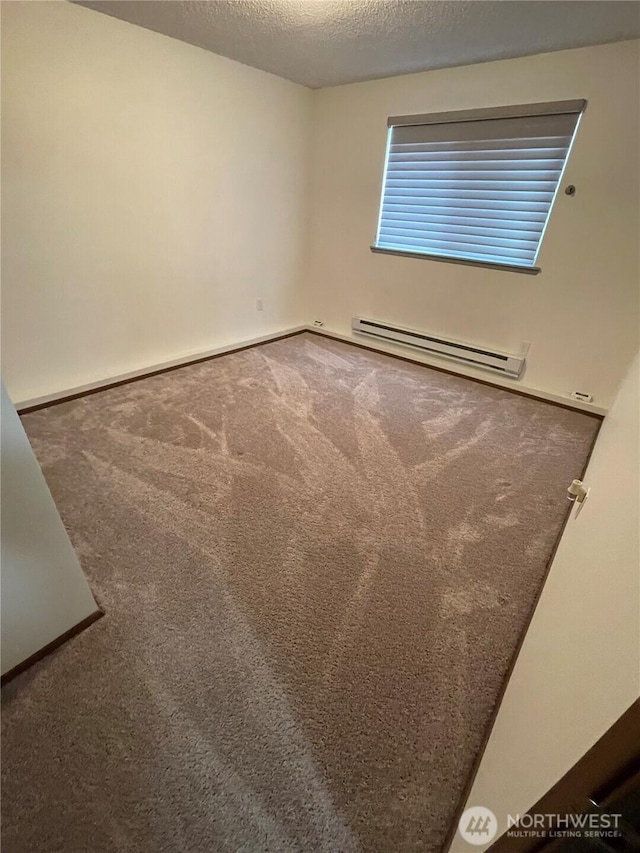 spare room with a textured ceiling, carpet, baseboards, and a baseboard radiator