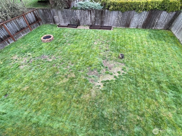 view of yard featuring a fenced backyard and an outdoor fire pit