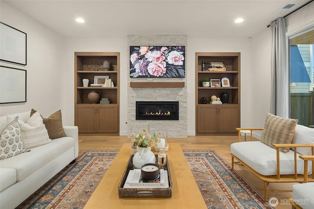 living room featuring recessed lighting, built in shelves, and wood finished floors