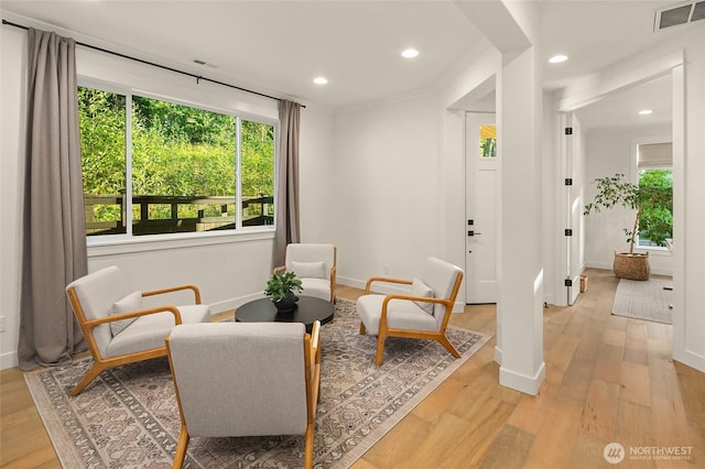 sitting room with light wood-type flooring, visible vents, baseboards, and recessed lighting