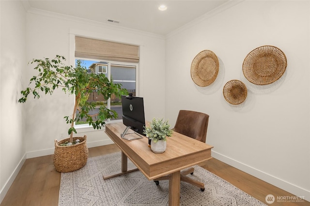 office space featuring a healthy amount of sunlight, crown molding, baseboards, and wood finished floors