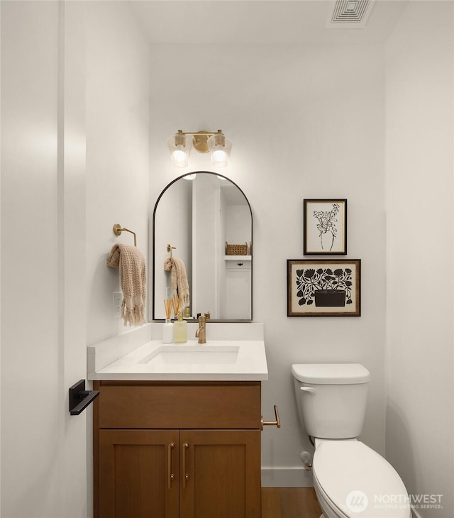 bathroom with visible vents, toilet, vanity, and baseboards