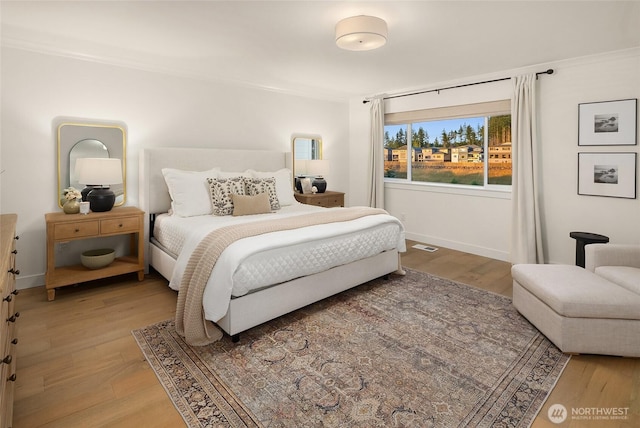 bedroom featuring visible vents, baseboards, and light wood-style floors