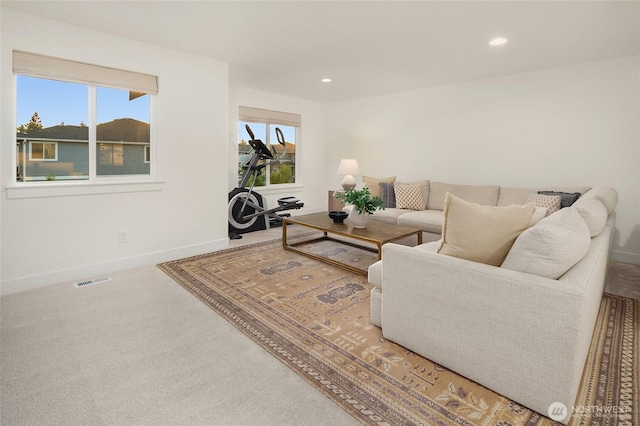 carpeted living area with visible vents, recessed lighting, and baseboards