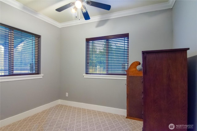 carpeted spare room with a ceiling fan, baseboards, and a wealth of natural light