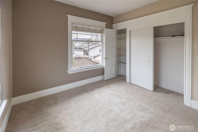 unfurnished bedroom with baseboards, carpet floors, and a closet