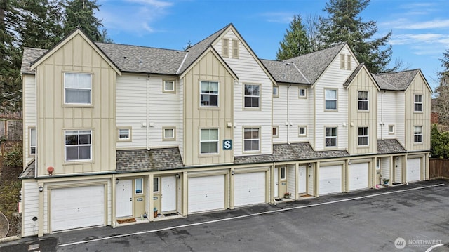 multi unit property featuring a garage, board and batten siding, and roof with shingles