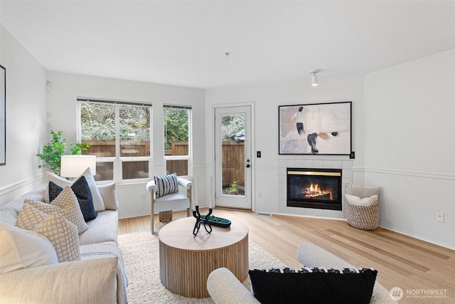 living room with wood finished floors and a tile fireplace