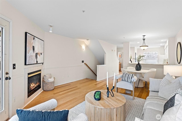 living room with wood finished floors and a tiled fireplace