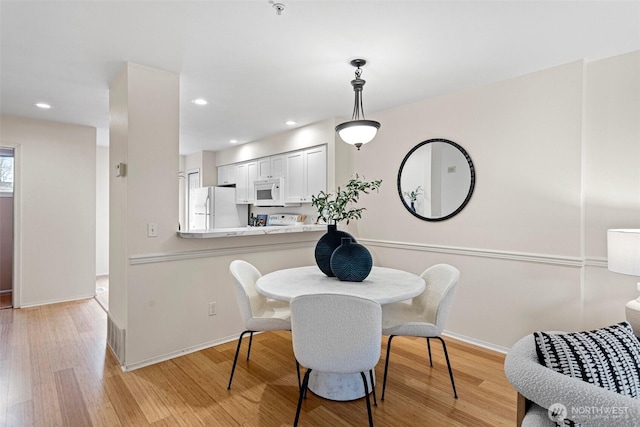 dining room with light wood-style flooring, recessed lighting, and baseboards