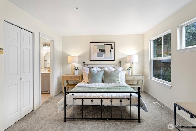 bedroom featuring baseboards, visible vents, arched walkways, and light carpet