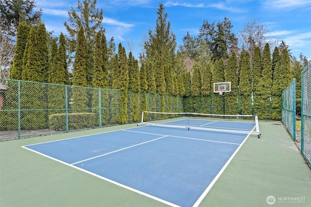 view of tennis court featuring fence