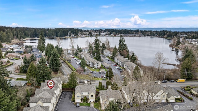 drone / aerial view with a wooded view and a water view