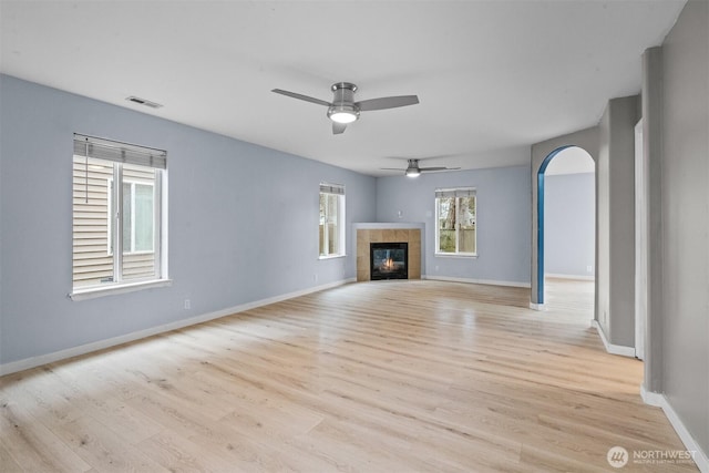 unfurnished living room featuring visible vents, baseboards, light wood-style floors, and a fireplace