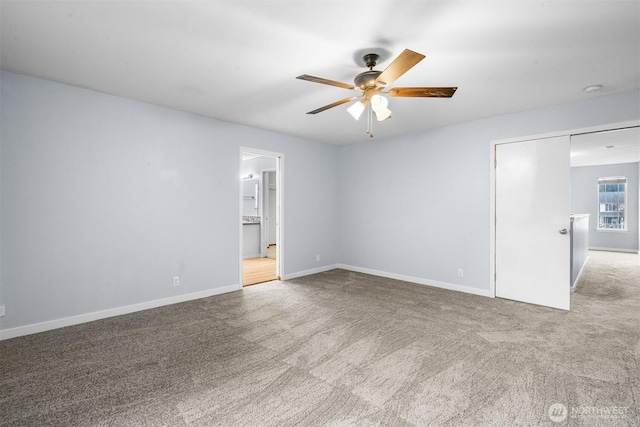 unfurnished bedroom with ensuite bath, baseboards, carpet, and a ceiling fan