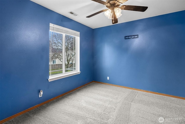 spare room with a ceiling fan, visible vents, carpet, and baseboards