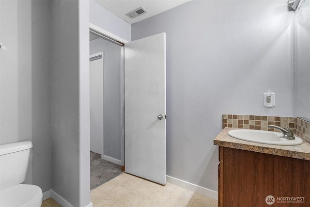 bathroom with visible vents, baseboards, toilet, decorative backsplash, and vanity