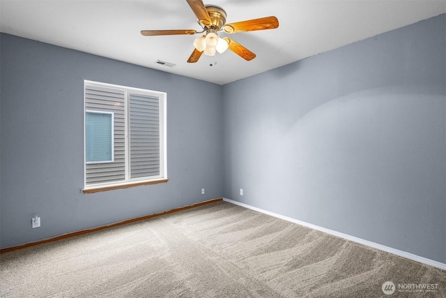 carpeted empty room with visible vents, baseboards, and a ceiling fan