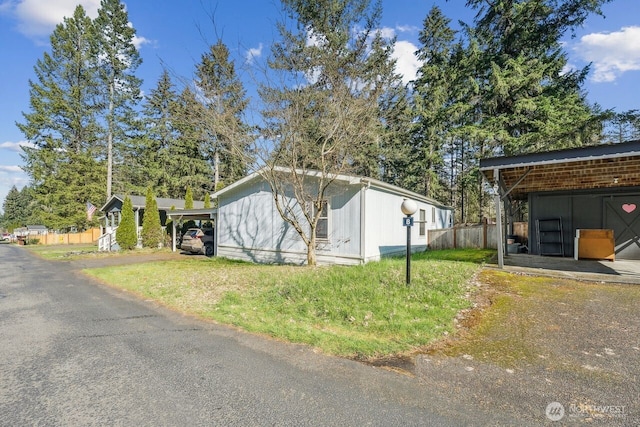 view of home's exterior with an outbuilding and fence