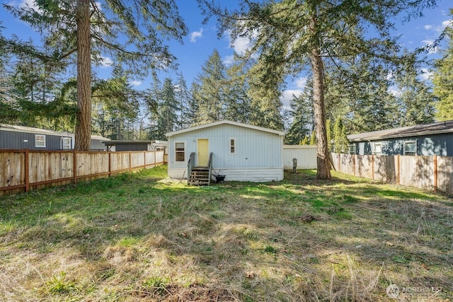 view of yard featuring entry steps and a fenced backyard