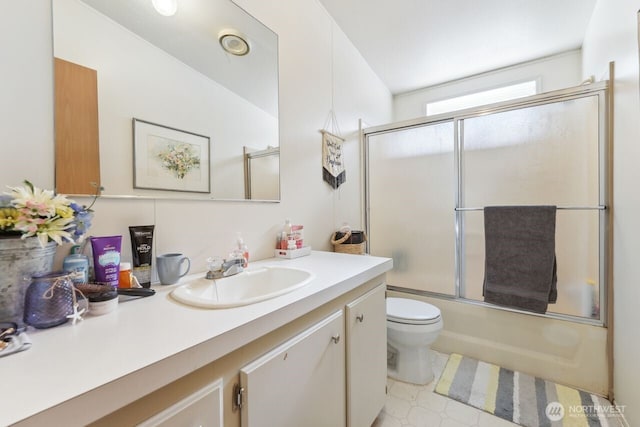 full bathroom with combined bath / shower with glass door, toilet, and vanity