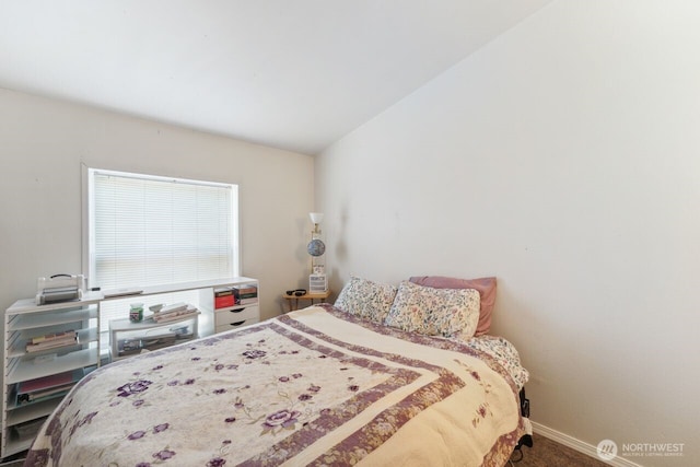 bedroom with lofted ceiling, baseboards, and carpet floors